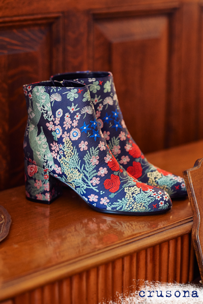 Pair of floral pattern booties on a tabletop.
