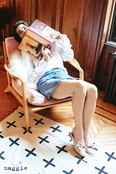 Woman leaning back in chair reading a magazine.