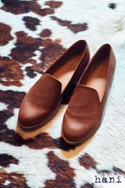 Pair of brown loafers on carpet.